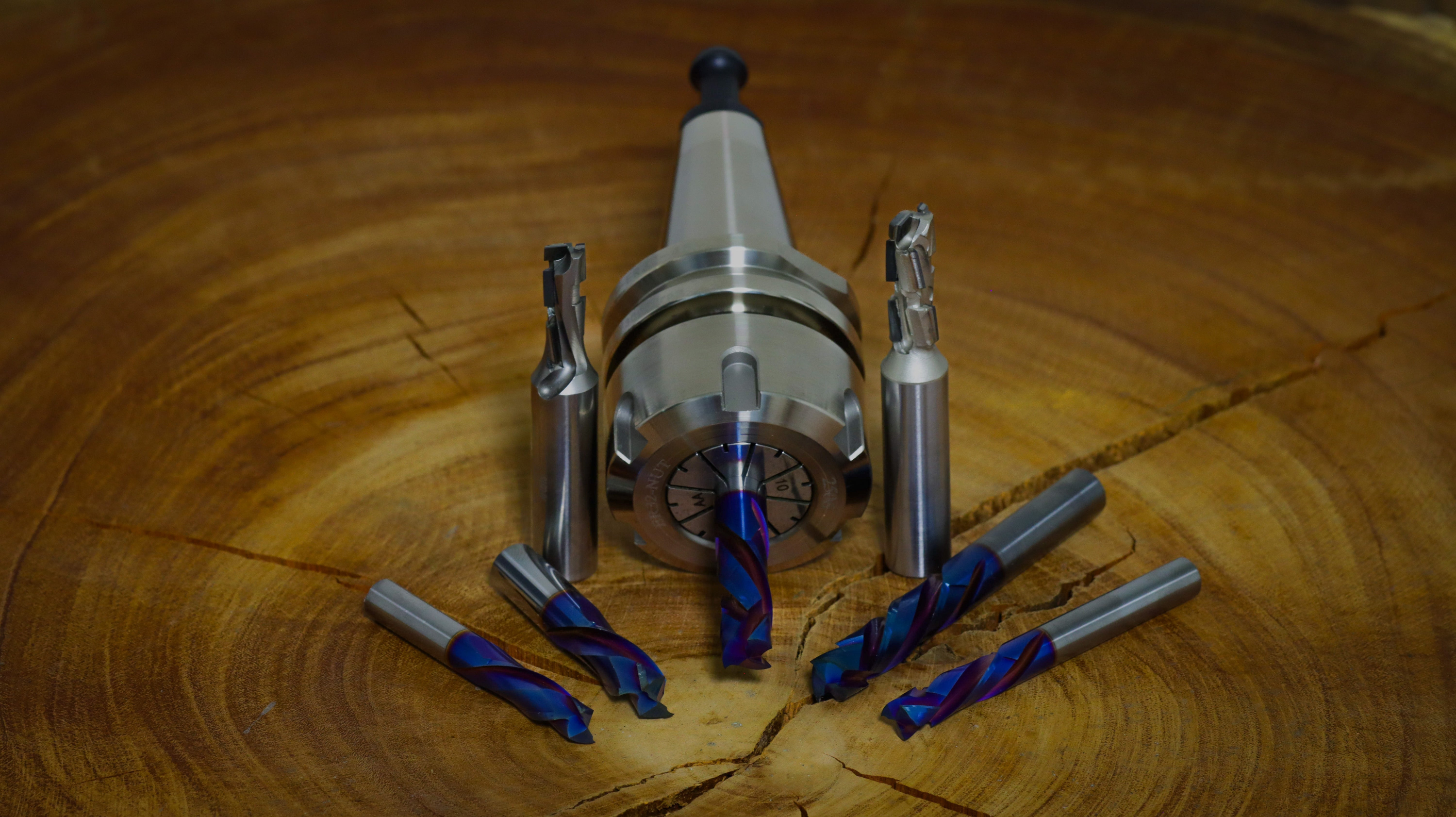 Atlas Tools Image of Tool Holder and Compression Router Bits on Wood Block front shot looking down at an angle